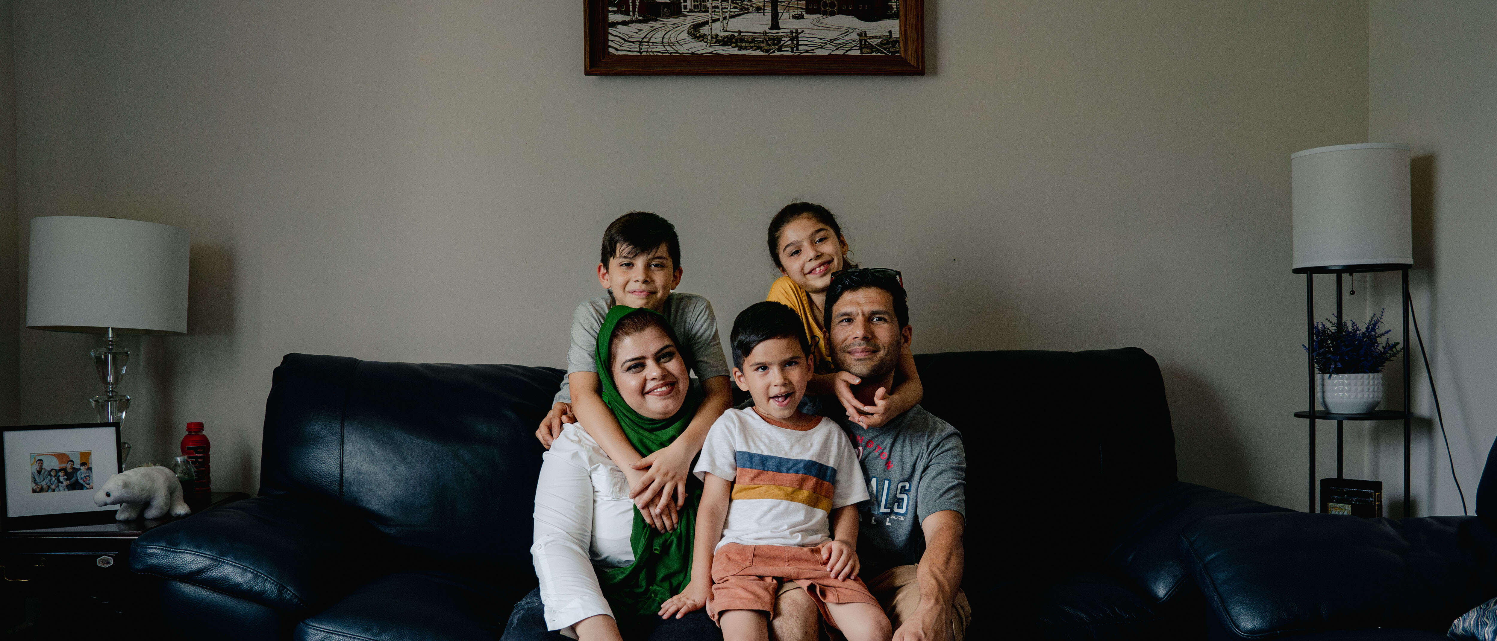 A family of five smile and pose together for a portrait.