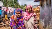 Two neighbors pose for a photo outside their home at the Keyra IDP site, Ethiopia.